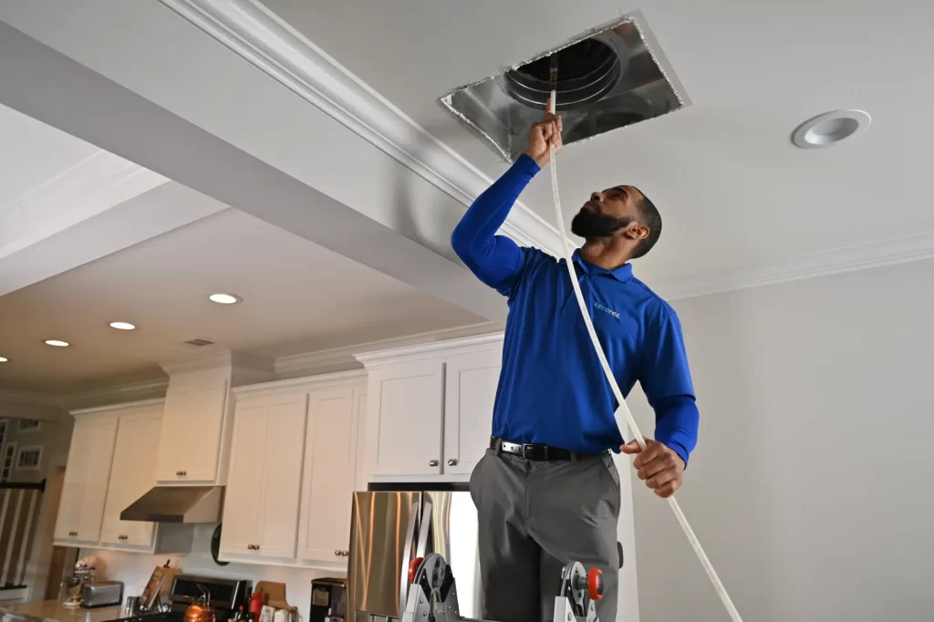 An HVAC tech cleaning ducts.