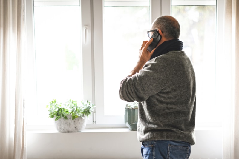 Why Won’t My Furnace Stop Running? Mature adult man working at home (radiator-heater, mobile phone).