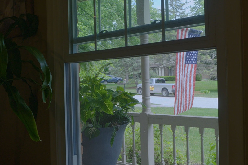 Video - Energy Saving Tip 6. Window looking out to front porch and American flag.