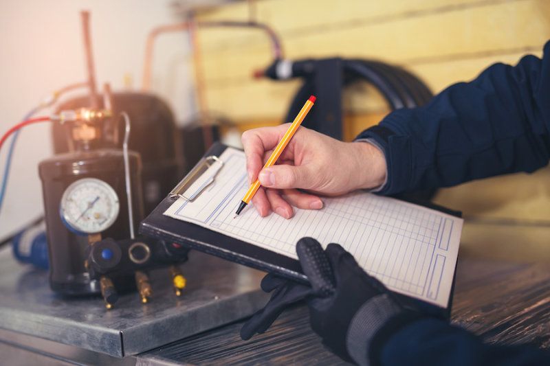 A HVAC tech uses a clipboard. How Do I Know When I Need a New Furnace?